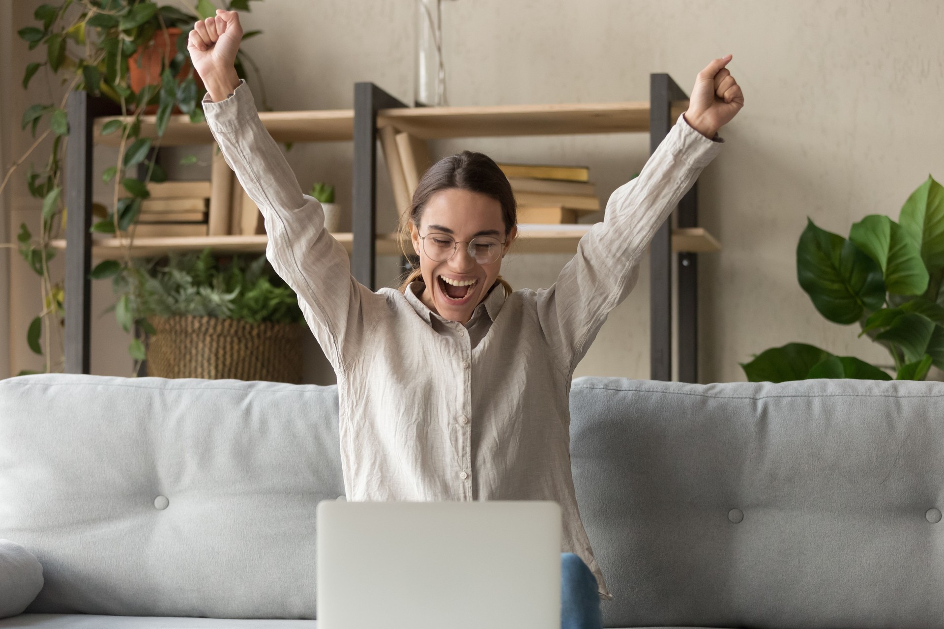 Excited young woman feel euphoric reading news at laptop