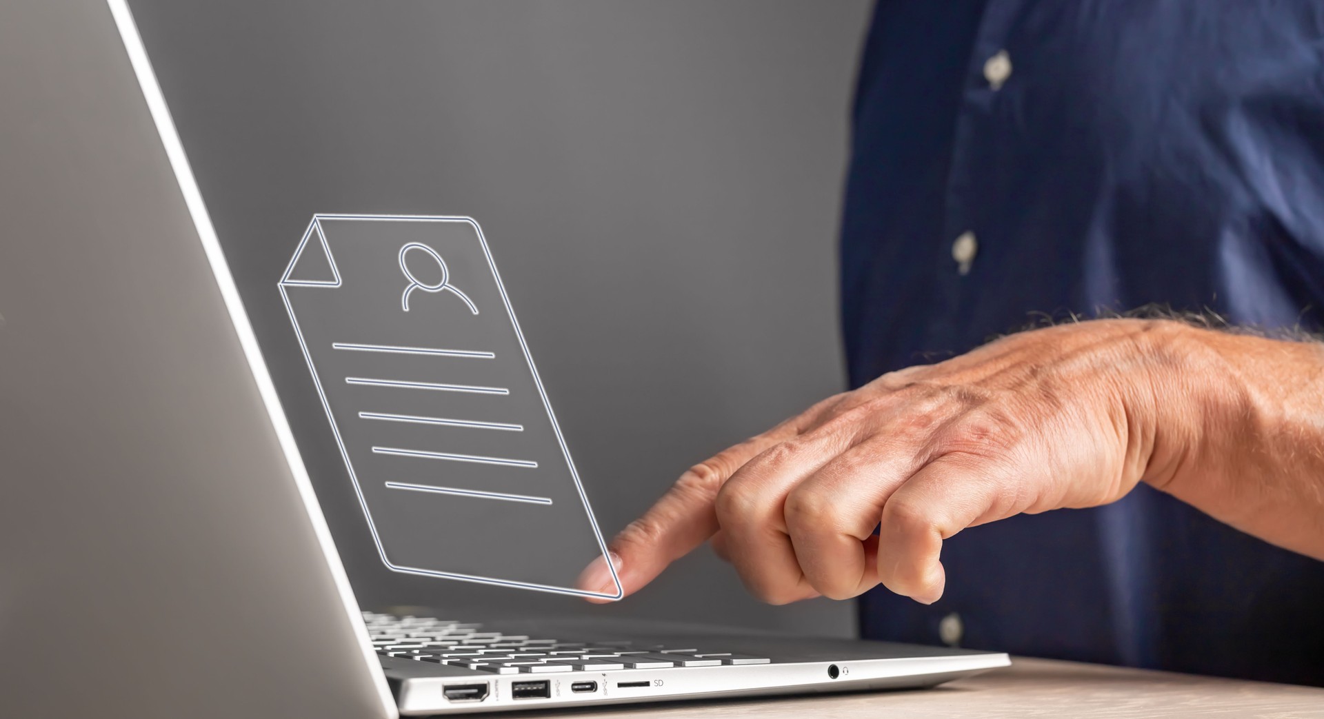 Man using laptop for sending CV, application. Forefinger pressing enter button closeup. Hiring, recruitment concept. Male sitting at table with computer.