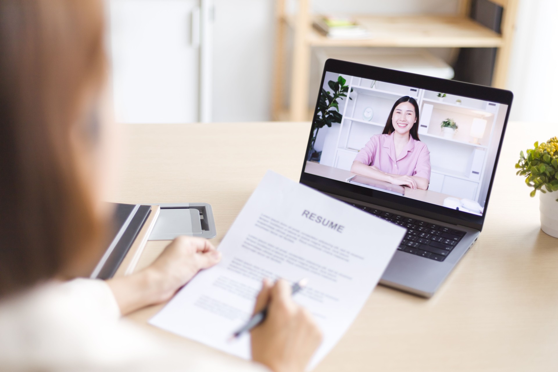Asian woman human resource interviewing a job candidate via video conference.